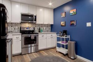 a kitchen with white cabinets and a blue wall at Fantastic Falls Church HomeBase for DC area travel in Arlington
