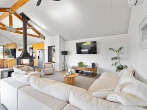 a living room with white furniture and a fireplace at Casa Burnside in Margaret River Town