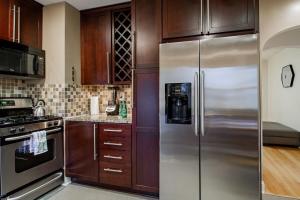 a kitchen with a stainless steel refrigerator and wooden cabinets at Pentagon City Homestay Parking available in Arlington +11 photos