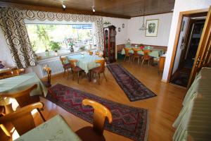 een eetkamer met tafels en stoelen en een raam bij Pension Weinberg mit Landhaus Nizza in Gleisweiler