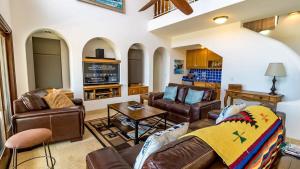 a living room with leather furniture and a tv at Easy access to South Palmilla beach in El Bedito