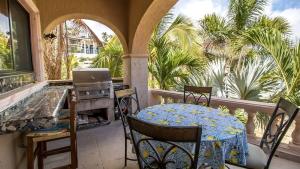 a balcony with a table and a stove and palm trees at Easy access to South Palmilla beach in El Bedito