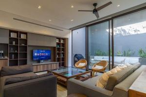 a living room with two couches and a tv at Amazing penthouse in the heart of Cabo San Lucas marina in Cabo San Lucas