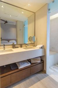 a bathroom with a sink and a large mirror at Amazing penthouse in the heart of Cabo San Lucas marina in Cabo San Lucas