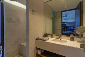 a bathroom with a sink and a large mirror at Amazing penthouse in the heart of Cabo San Lucas marina in Cabo San Lucas