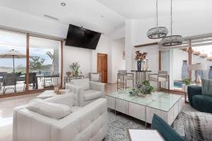 a living room with white furniture and a table at Gorgeous estate in Puerto Los Cabos golf and beach community in San José del Cabo