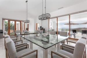 a dining room with a glass table and chairs at Gorgeous estate in Puerto Los Cabos golf and beach community in San José del Cabo