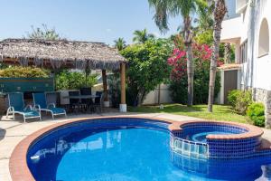 a swimming pool in a yard with a table and chairs at Villa Calafia Spacious Home w Private Tennis in Cabo San Lucas