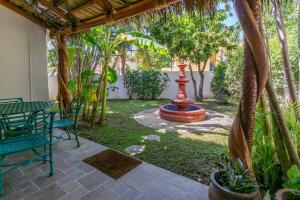 a patio with a fountain and chairs and trees at Villa Calafia Spacious Home w Private Tennis in Cabo San Lucas