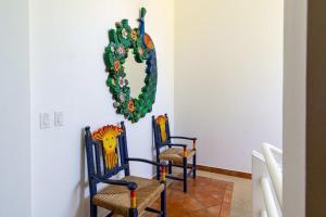 two chairs in a room with a wreath on the wall at Villa Calafia Spacious Home w Private Tennis in Cabo San Lucas