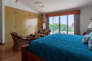 a bedroom with a blue bed and a balcony at Villa Calafia Spacious Home w Private Tennis in Cabo San Lucas