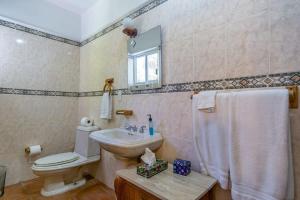 a bathroom with a toilet and a sink and a mirror at Villa Calafia Spacious Home w Private Tennis in Cabo San Lucas
