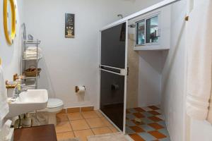 a small bathroom with a toilet and a sink at Villa Calafia Spacious Home w Private Tennis in Cabo San Lucas