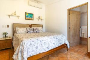 a bedroom with a bed and a door to a bathroom at Villa Calafia Spacious Home w Private Tennis in Cabo San Lucas