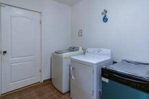 a small laundry room with a washer and dryer at Villa Calafia Spacious Home w Private Tennis in Cabo San Lucas