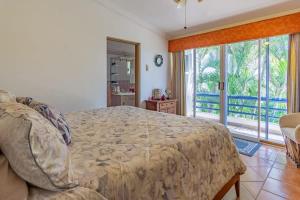 a bedroom with a bed and a large window at Villa Calafia Spacious Home w Private Tennis in Cabo San Lucas