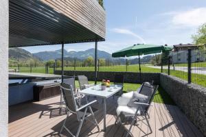 a patio with a table and chairs and an umbrella at Haus Alpenlieb in Wörgl