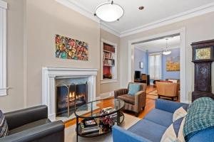 a living room with a fireplace and a blue couch at Historic Capital Hill Home and Carriage House in Washington, D.C.