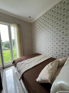 a bedroom with a large bed with a window at Casa Rani Batu Malang Villa in Batu