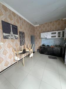 una habitación con 2 sillas y un cartel en la pared en Casa Rani Batu Malang Villa, en Batu