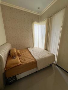 Cama pequeña en habitación con ventana en Casa Rani Batu Malang Villa, en Batu