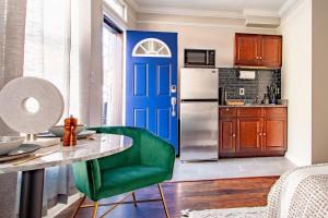 a kitchen with a blue door and a green chair at Little Penthouse in Little Italy Near Inner Harbor Studio in Baltimore