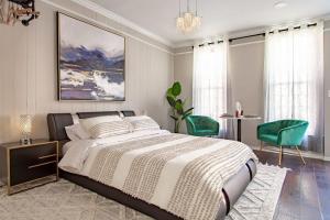 a bedroom with a bed and two green chairs at Little Penthouse in Little Italy Near Inner Harbor Studio in Baltimore