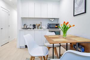 a kitchen with a wooden table and white chairs at Bright & Cozy 1-BR Alcove in Bloomingdale in Washington, D.C.