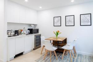 a kitchen with white cabinets and a table and chairs at Bright & Cozy 1-BR Alcove in Bloomingdale in Washington, D.C.
