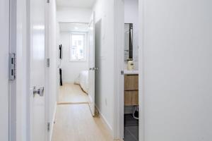 a hallway with white walls and a kitchen with a sink at Bright & Cozy 1-BR Alcove in Bloomingdale in Washington, D.C.