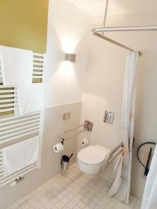 a small bathroom with a toilet and a light at Nymphe Strandhotel & Apartments in Binz