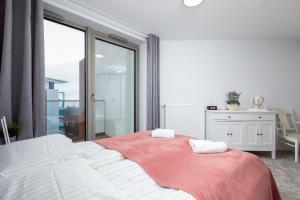 a white bedroom with a large bed and a window at Apartament Superior Sea View PINEA 701 in Pobierowo