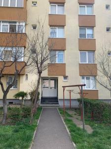 a building with a door and a sidewalk in front of it at Scandinavia Apartment 2 in Piatra Neamţ