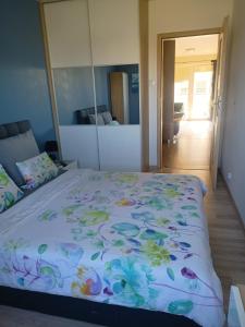 um quarto com uma cama com um edredão floral em Apartament Wichrowe Wzgórze Olsztyn em Olsztyn