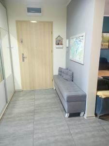 um quarto com uma porta e um sofá num quarto em Apartament Wichrowe Wzgórze Olsztyn em Olsztyn