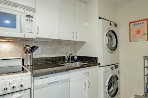 a white kitchen with a sink and a microwave at Gem off of 14th St NW Near U St & Logan Circle in Washington