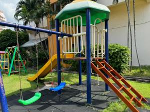 a playground with a slide and a swing set at Mina view condo 12 in Pattaya South