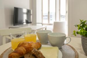a table with two cups of orange juice and a plate of food at ApptoAlejandro-Ribadesella in Ribadesella