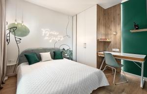 a bedroom with a white bed and a desk at Premium City Apartments in Bydgoszcz
