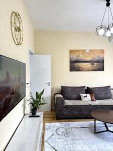 a living room with a couch and a tv at Sol Apartments - 2 Bedrooms in Shkodër