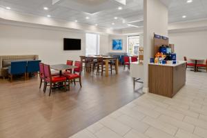 a waiting room with tables and chairs in a building at Holiday Inn Express Stony Brook-Long Island by IHG in Centereach