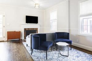 a living room with two blue chairs and a tv at Historic Charming Home in Old Town in Alexandria