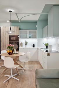 比得哥什的住宿－Premium City Apartments，厨房配有白色橱柜和桌椅