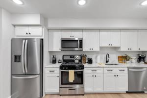 a kitchen with stainless steel appliances and white cabinets at Excellent 2-BR Condo in Hip Area of DC in Washington, D.C.