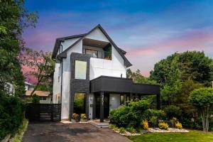 阿林顿Top of The Hill Luxury Clarendon 4-BR Homestay的一栋带有黑色屋顶的白色房子