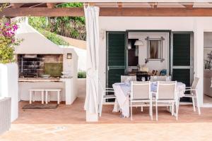a patio with a table and chairs and a fireplace at Villa Kingfisher in Cala Llonga