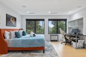 阿林顿Top of The Hill Luxury Clarendon 4-BR Homestay的一间卧室，配有一张床和一张带电脑的书桌