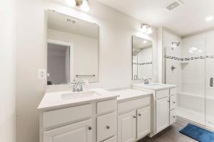 uma casa de banho branca com 2 lavatórios e um espelho grande em Ashburn 4-BR Homestay Close to Dulles & METRO em Brambleton