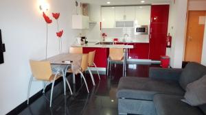 a kitchen and living room with a table and a couch at Rocha T Apartments in Portimão