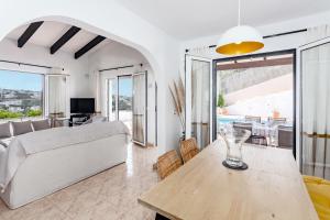 a living room with a table and a couch at Villa Kingfisher in Cala Llonga
